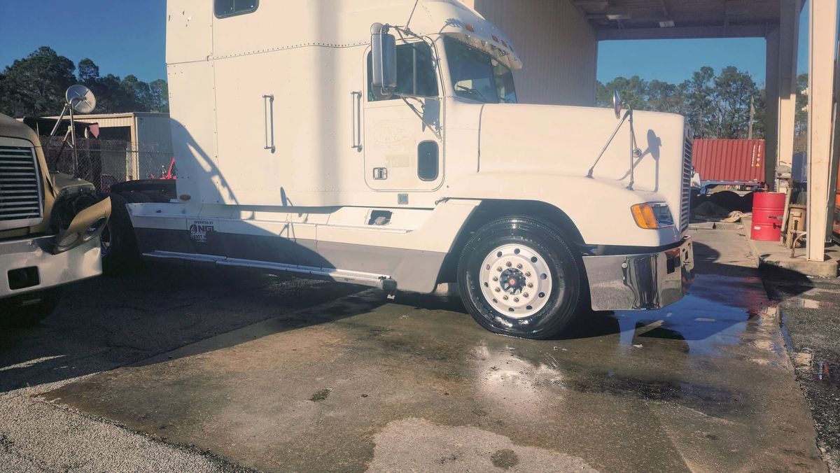 White semi truck being washed at a truck yard